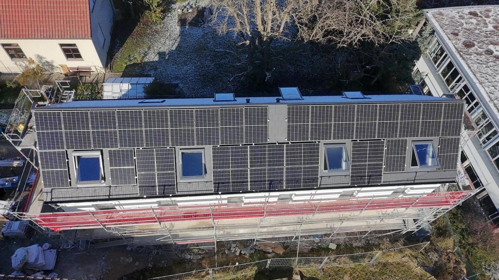 Luftaufnahme eines Hausdachs, vollständig mit Photovoltaik-Modulen belegt