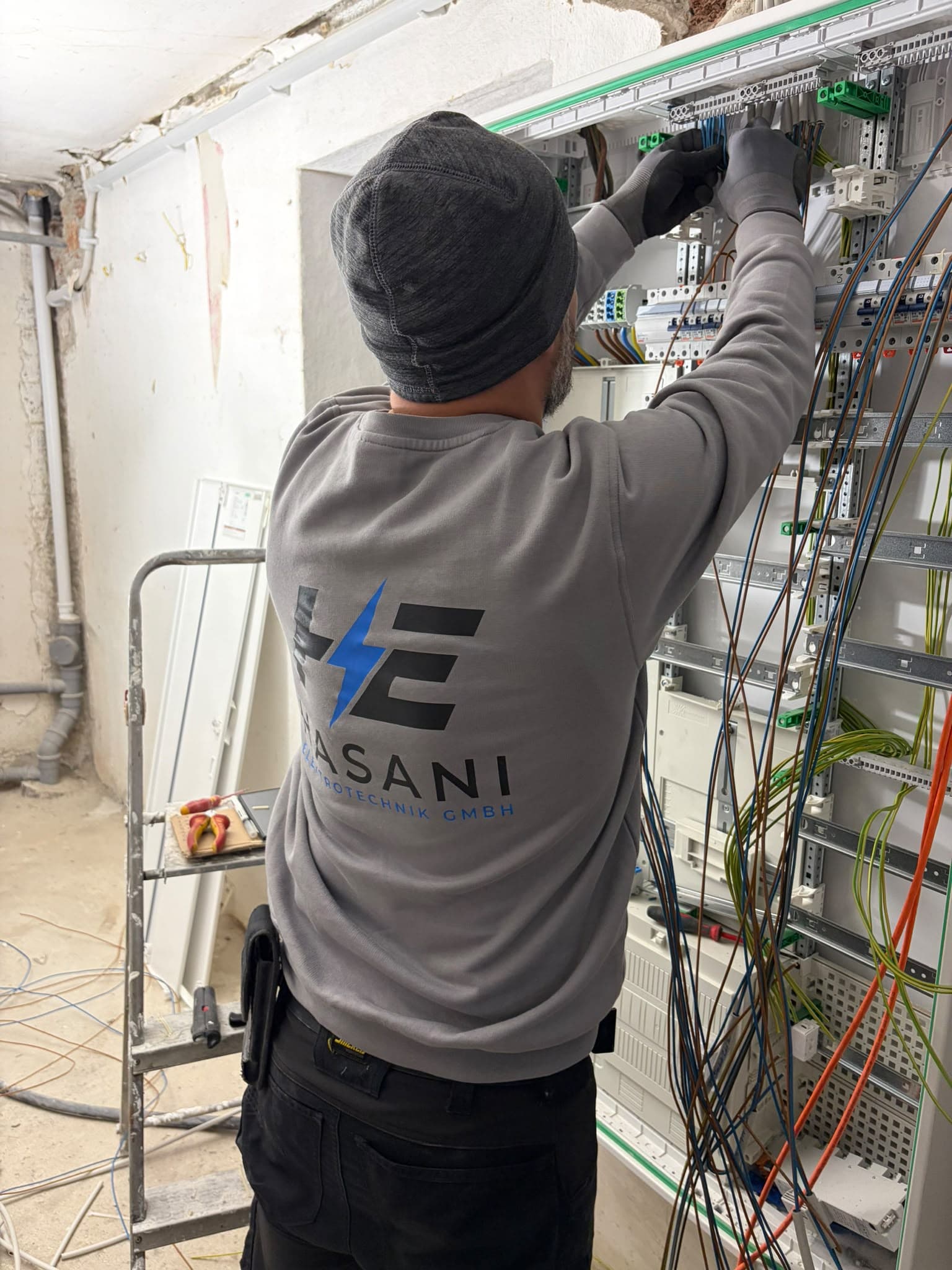 Mitarbeiter der Hasani Elektrotechnik GmbH verdrahtet einen Verteilerschrank